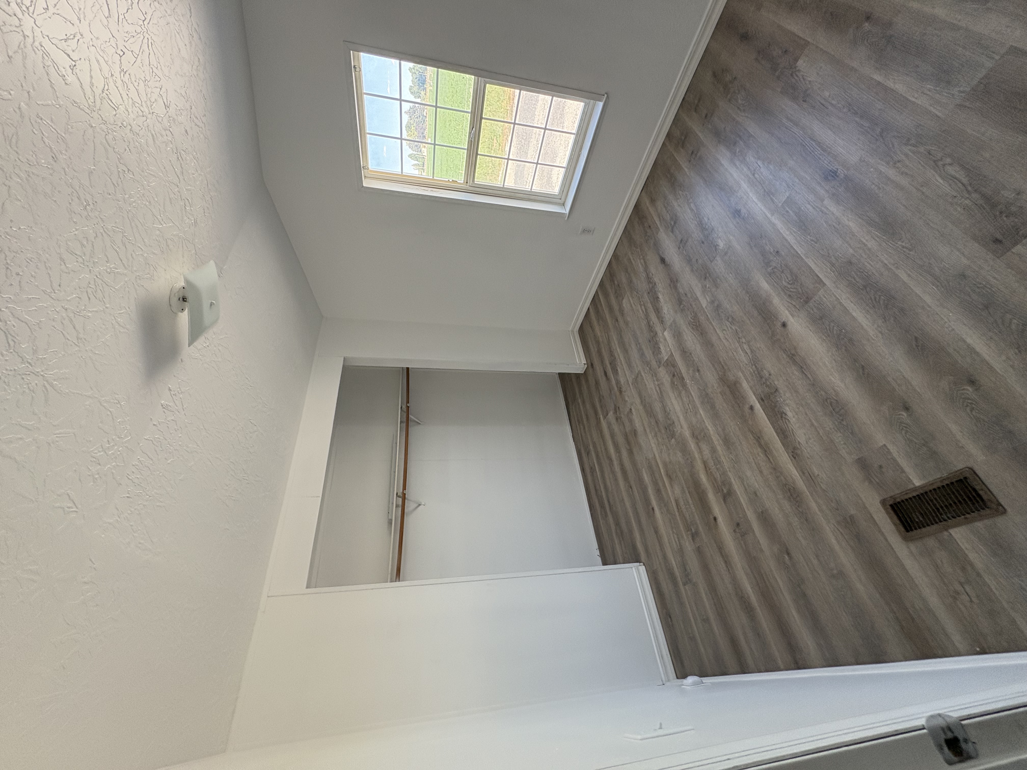 Finished bedroom with new LVP, closet rod and window
