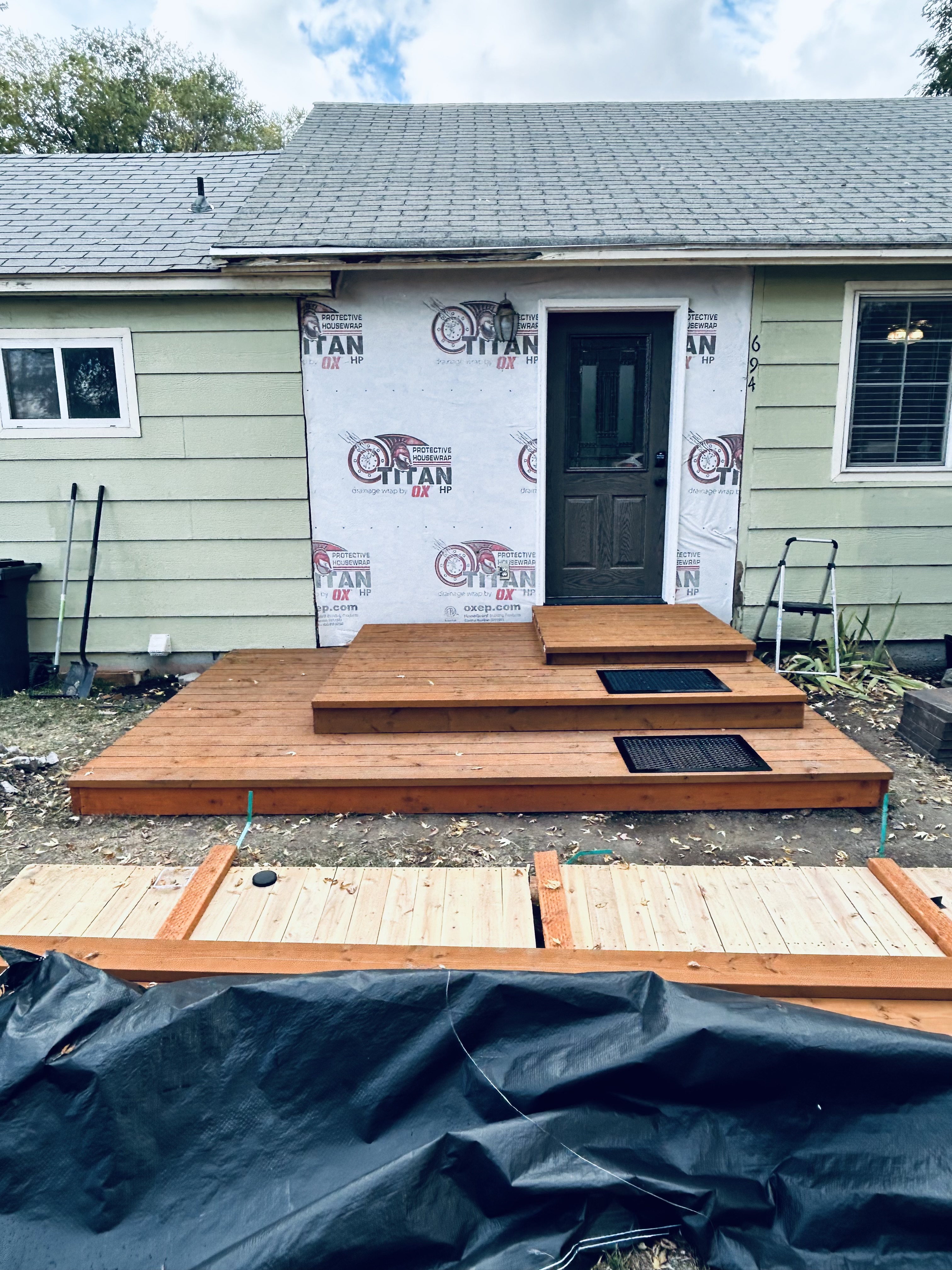 Stamped concrete patio – wide view with upper deck and red log posts