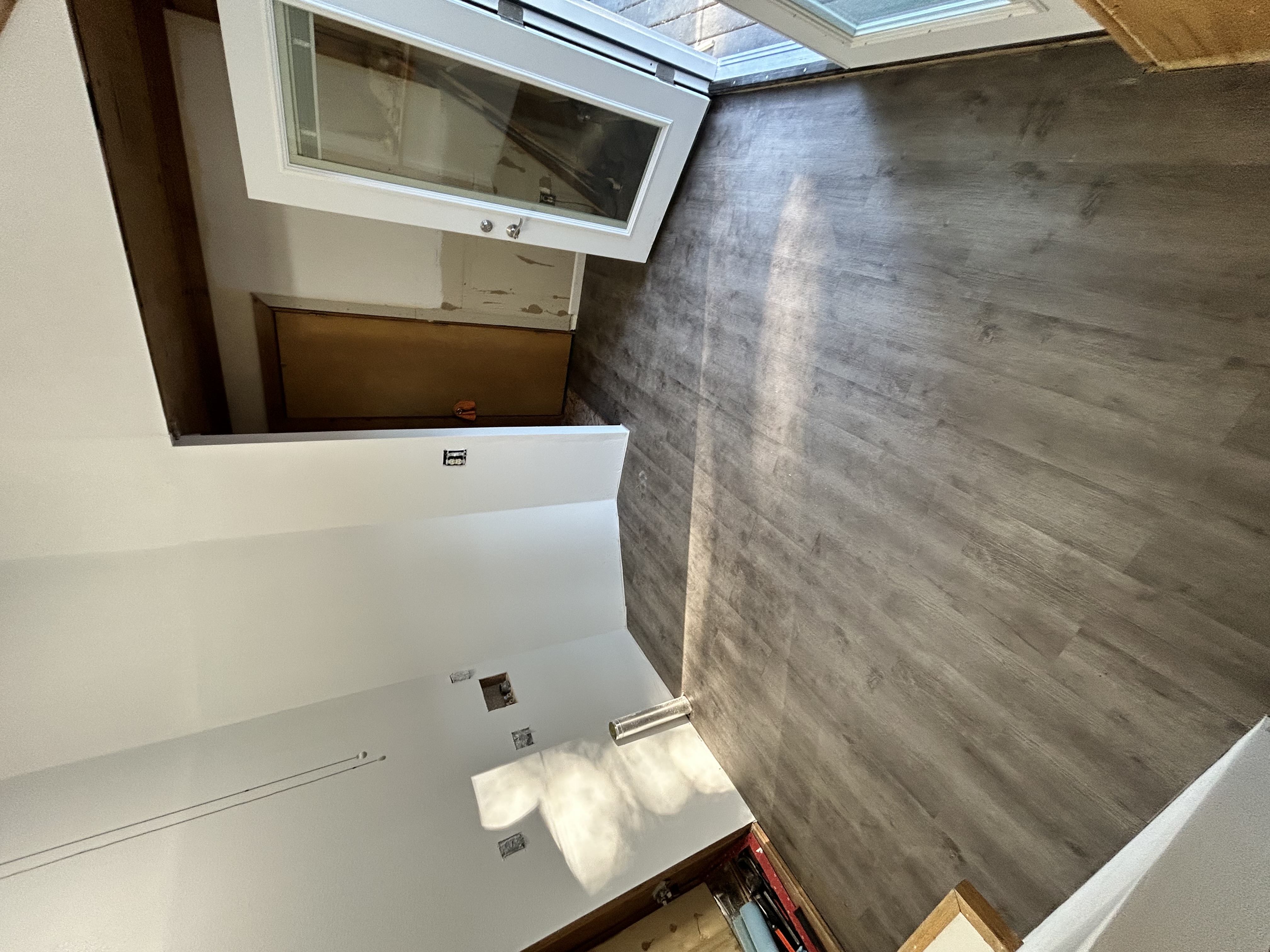 Vaulted room with new LVP and French door mid-install